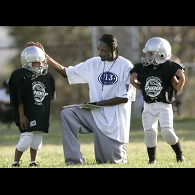 Snoop Dogg (Calvin Broadus) talks with one of his Snoop Youth Football League players during practi